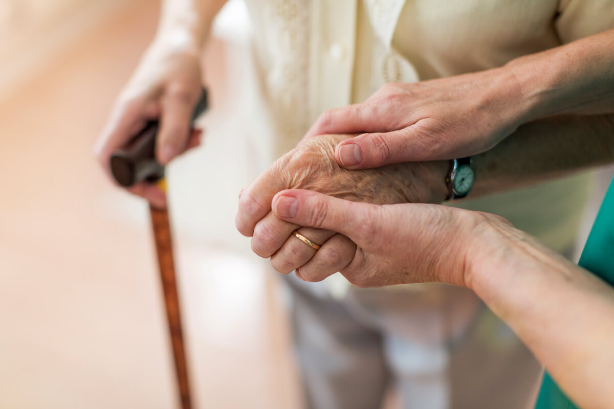 A caregiver holding hands with a senior_Brickmont Assisted Living